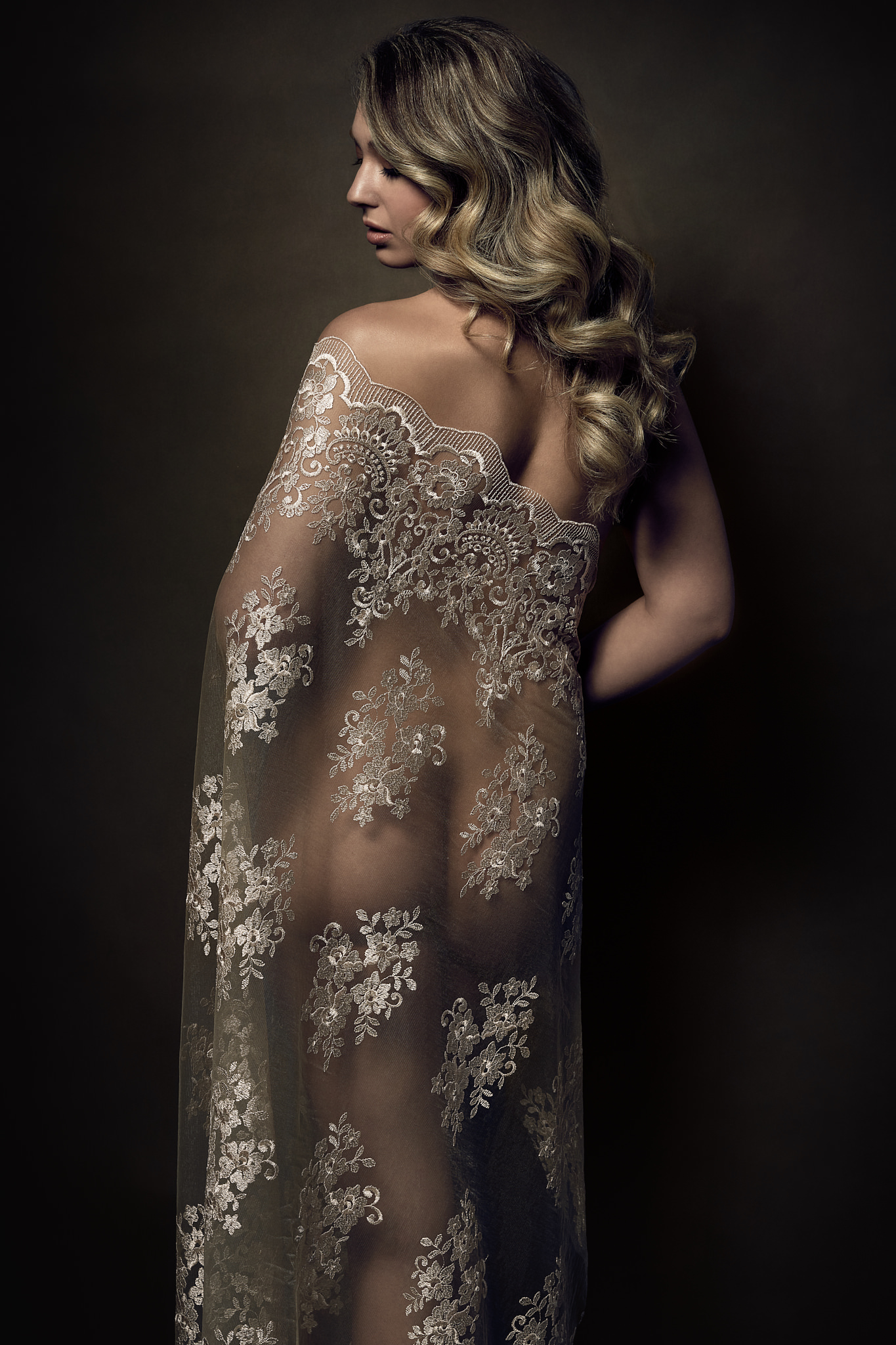 Boudoir Portrait of a blond woman's back draped in lace